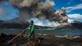 Tavurvur, Papua-Neuguinea  Munganau kennt nichts anderes als das  Leben mit dem Tavurvur. Seit­ dem er auf der  Welt ist, spuckt der Vulkan fast täglich Asche,  Lavabomben und lässt den Himmel nachts  leuchten.