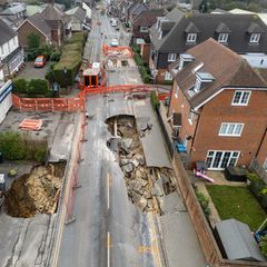 Zwei Krater klaffen in der Hauptstraße des Dörfchens Godstone südlich von London. Die umliegenden Häuser wurden evakuiert