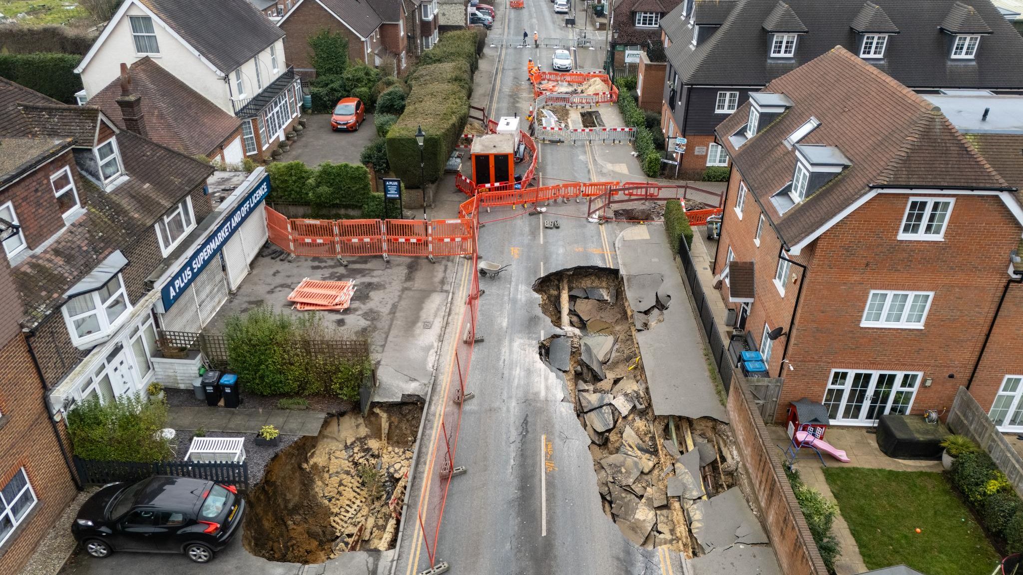 Zwei Krater klaffen in der Hauptstraße des Dörfchens Godstone südlich von London. Die umliegenden Häuser wurden evakuiert