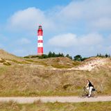 Nur zehn Kilometer lang und zwei Kilometer breit – ein Riese unter den Insel ist Amrum nicht, hält aber trotzdem tolle Radtouren bereit. Auf der Strecke von Norddorf im Norden bis nach Wittdün im Süden warten Dünen, Watvögel, Wattenmeer und Wald bis hin zu einem der größten Leuchttürme an der deutschen Nordseeküste. Die gut 30 Kilometer lange und flache Route ist gut für Familien geeignet. Der weite Blick aufs Wattenmeer und die Nordsee beim Radeln abseits der Straßen ist ebenso schön wie die verdiente Pause am Leuchtturm Amrum von 1875. Der rot-weiße geringelte Riese ragt bei Wittdün 63 Meter in die Höhe und ist als Aussichtsplattform sogar im Winter mittwochs von 9 Uhr und 12.30 Uhr geöffnet.