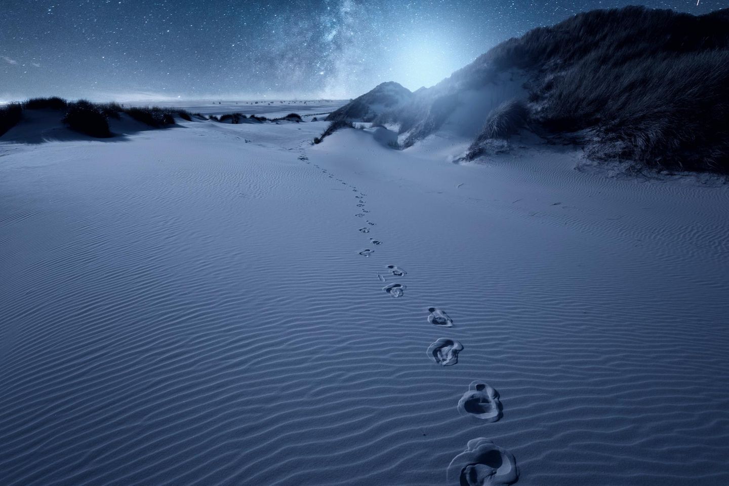 Wenn um Mitternacht die Straßenbeleuchtung auf Amrum abgeschaltet wird und nur noch der Mond die Dünen erhellt, legt sich die Dunkelheit über die Insel. Ist der Himmel klar, erweitert eine Wanderung durch die Dünen im wahrsten Sinne des Wortes den Horizont – nach oben. Sterne funkeln, die Milchstraße steht mit ihrem silbernen Glanz über den Köpfen, mit Glück huschen Sternschnuppen vorbei, absolute Stille. Dark Sky Wanderungen auf Amrum sind ein einmaliges Erlebnis, das um die drei Stunden dauert, meist ab 12 Jahren ist und aus gutem Grund keine Smartphones oder Hunde erlaubt. Eingehüllt in eine warme Decke auf der Isomatte am Strand, ist außer den leisen Erklärungen des Führers zum Sternenhimmel nichts zu hören. Wie treffend, dass der Dark-Sky-Guide auf Amrum tatsächlich Dark Blome heißt.