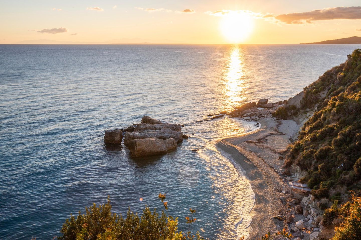 Zakynthos Versteckte Bucht am Mittelmeer zum Sonnenaufgang, der kleine Strand aus Sand und Kieselsteinen in den warmen Farben der Morgendämmerung, Blick auf das Meer am Xigia Sulfur Beach, Zakynthos, Ionische Inseln, Griechenland