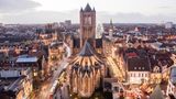 Man sieht die Stadt in der beginnenden Dämmerung. Straßenlichter leuchten. Der Blick fällt von oben auf St.-Bavo-Kathedrale.