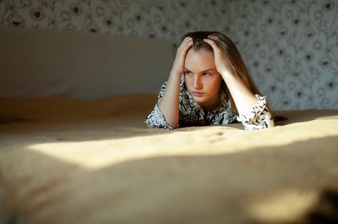Frau liegt auf einem Bett