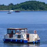 Mit einem Hausboot sind Urlauber auf der Kleinen Müritz in der Mecklenburgischen Seenplatte unterwegs