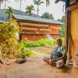 Frau, dahinter trocknender Mais