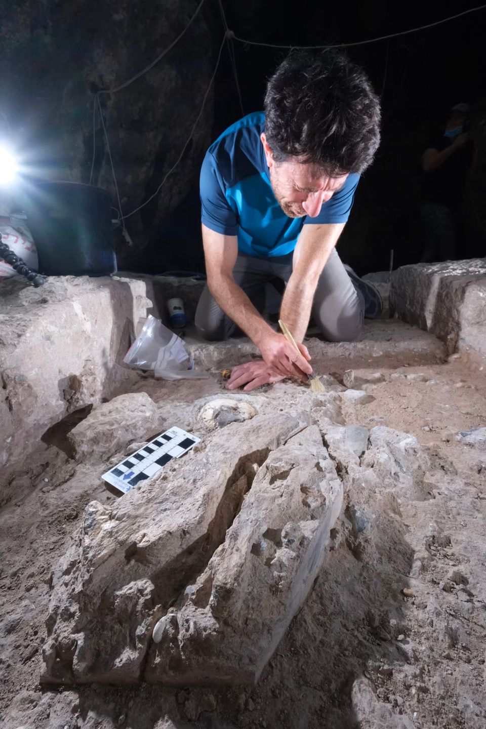 Ein Archäologe präpariert mit einem Pinsel mehr als 100.000 Jahre alte Gebeine