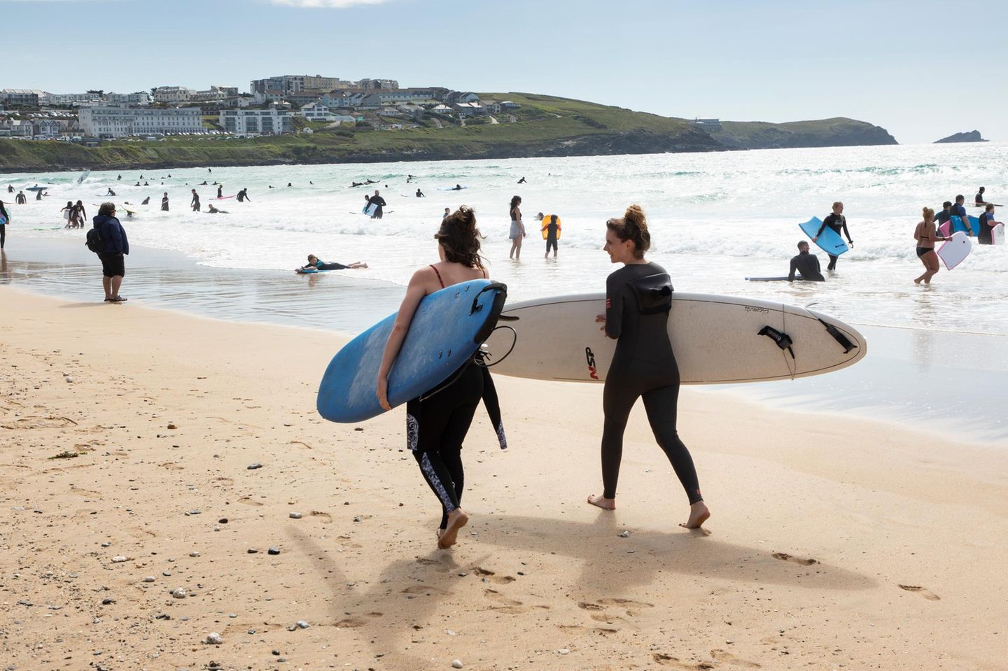 Zwei Surferinnen in Cornwall am Strand