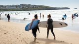 Zwei Surferinnen in Cornwall am Strand