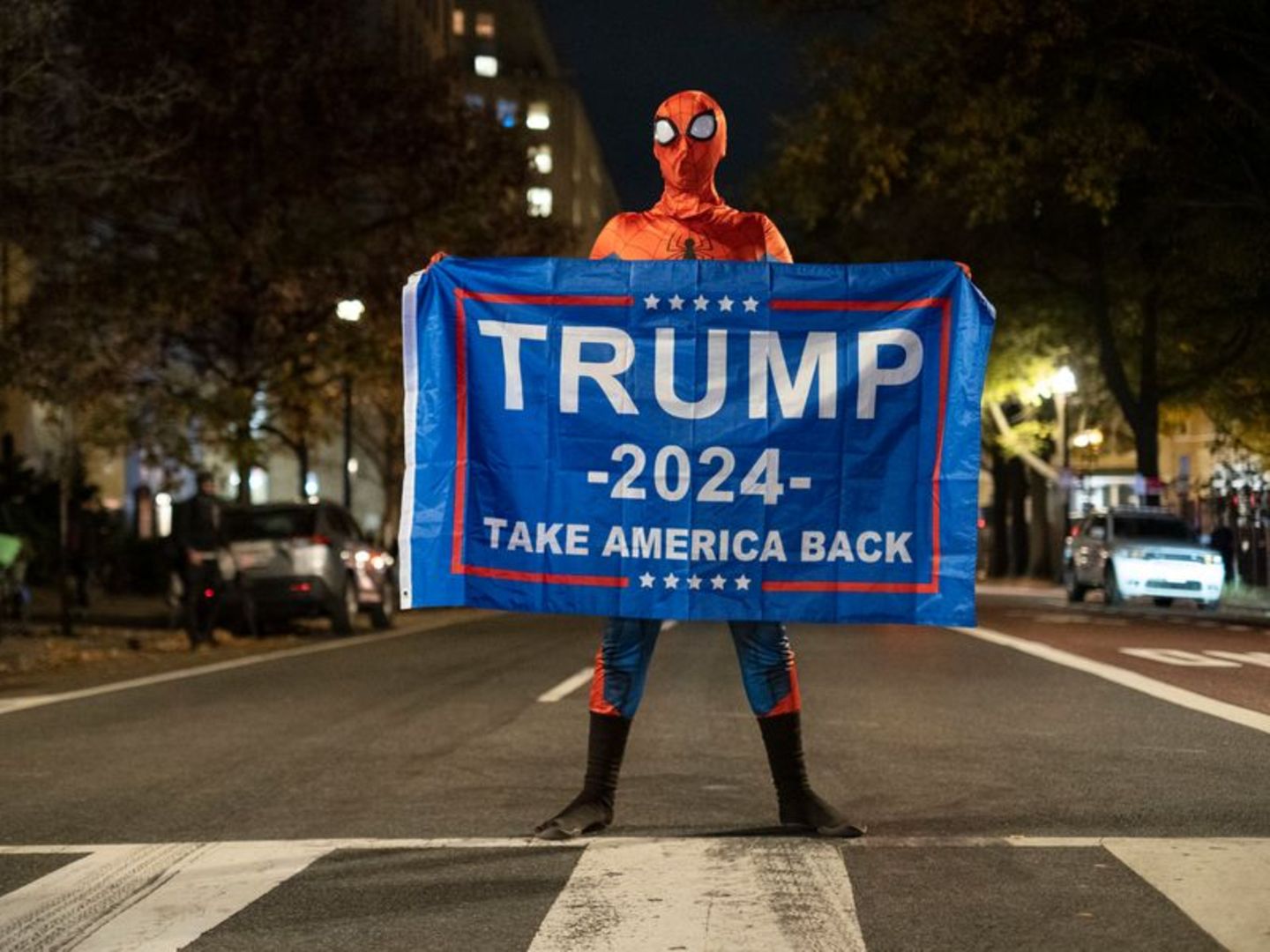 Trump-Unterstützer im Spider-Man-Kostüm mit einem Trump-Transparent am Tag der US-Präsidentschaftswahl 2024 in Washington