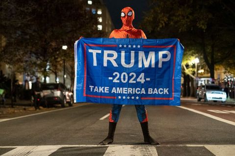 Trump-Unterstützer im Spider-Man-Kostüm mit einem Trump-Transparent am Tag der US-Präsidentschaftswahl 2024 in Washington