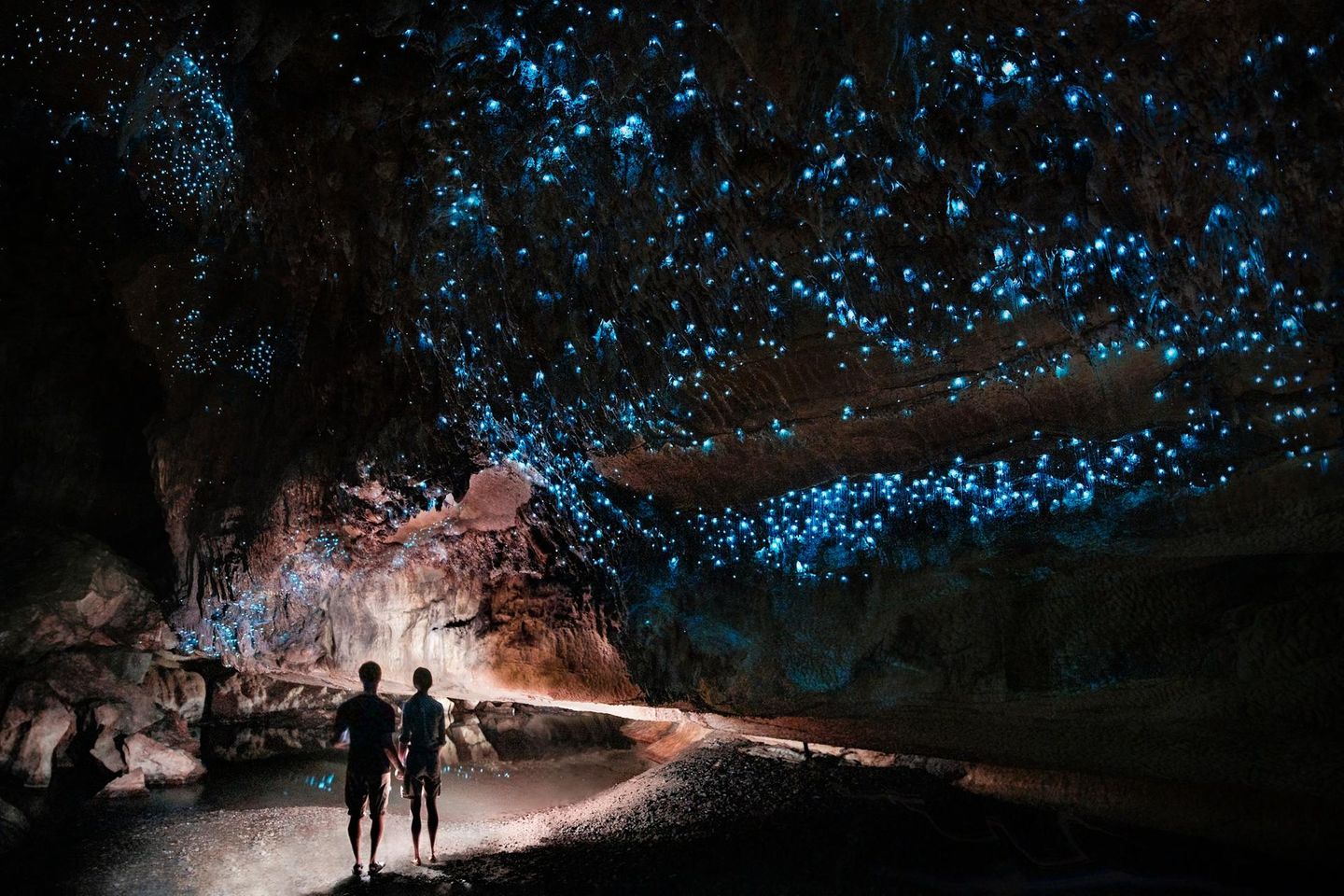 Besucher in der leuchtenden Waitomo-Höhle in Neuseeland