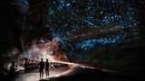 Besucher in der leuchtenden Waitomo-Höhle in Neuseeland