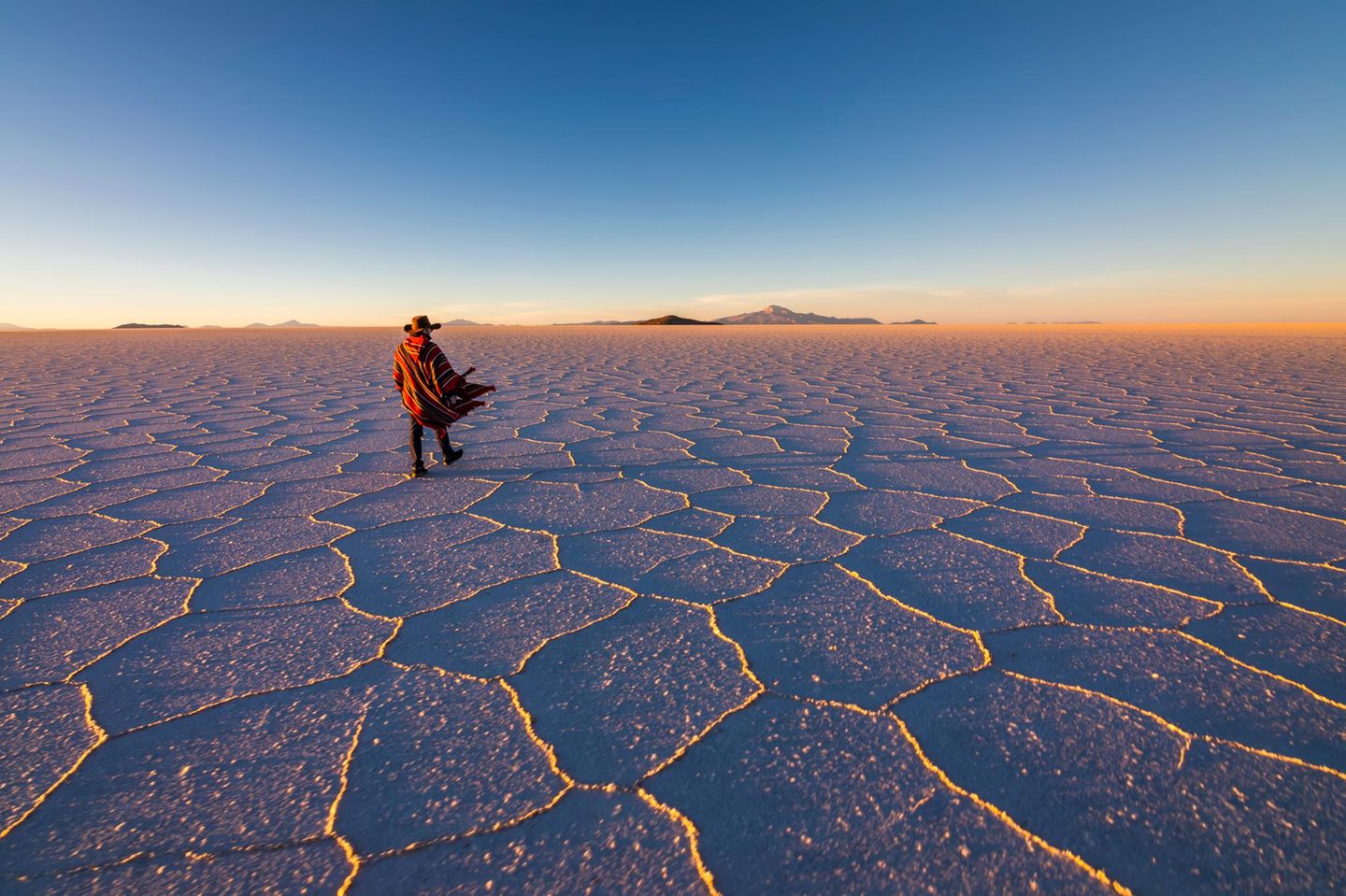 Salar de Uyuni, Bolivien Mann läuft durch die Salar de Uyuni in Bolivien bei Sonnenuntergang