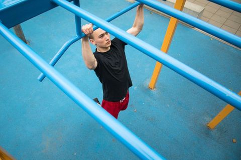 Junger Mann übt Klimmzüge