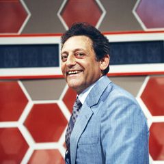 Quizmaster Hans Rosenthal lacht, gekleidet in ein blaues Jackett, in die Kamera