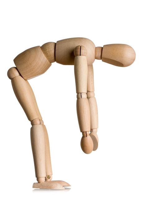 Eine hölzerne Puppe beugt sich vorwärts und lässt die Arme baumeln