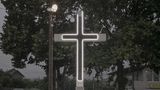 An einer Straße erinnert ein Neonkreuz im Stil von Wedding Chapels in Las Vegas an das Christentum.