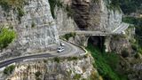 Pkws fahren zwischen Amalfi und Positano die Straße "Amalfitana" an der Amalfiküste entlang. Die Amalfitana zählt zu den schönsten Küstenstraßen der Welt und wurde im Jahre 1857 eröffnet.