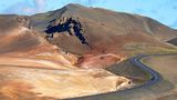 Die Ringroad vor den von vulkanischen Dämpfen in Rottoenen gefärbten Bergen des Dalfjall am Myvatnsee im Norden Islands