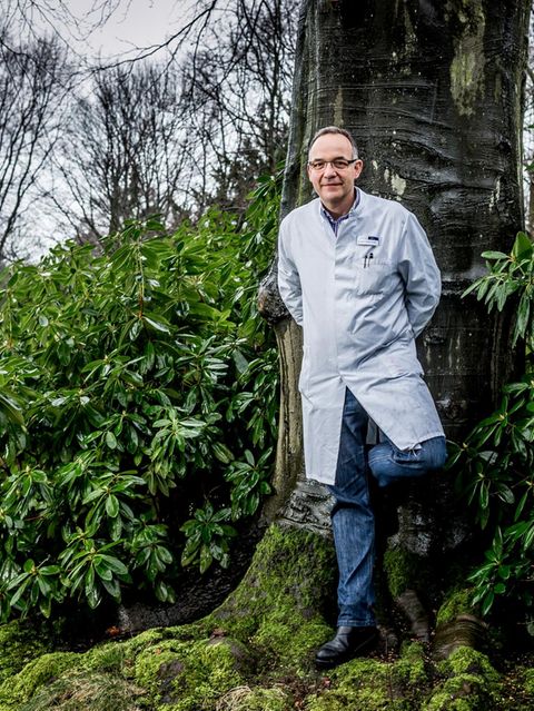 Dr. Claudio Finetti steht vor einem Baum und schaut in die Kamera