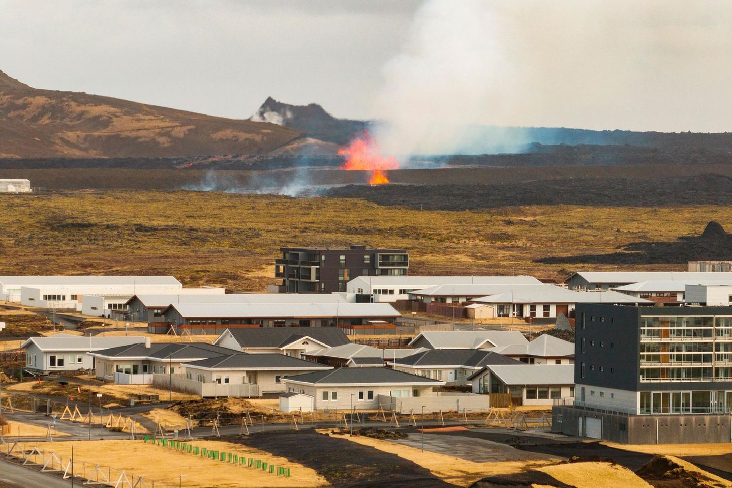 Austretende Lava bedroht Grindavík Grindavík mit Lava im Hintergrund