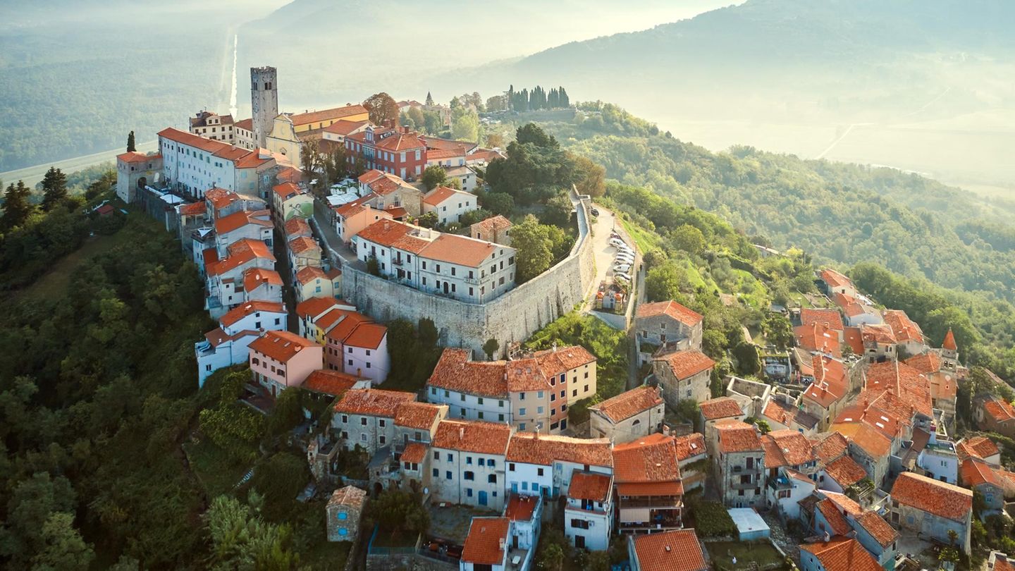 Motovun: ein Dorf fast im Himmel Altes Dorf auf einem Berg, dahinter Dunst und Hügelketten