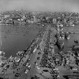 Uralt sind die Wurzeln Istanbuls. Über die Jahrtausende trägt die Stadt verschiedene Namen, erlebt römische, byzantinische und schließlich osmanische Herren, bis sie 1923 zur größten Metropole der türkischen Republik wird, wenn auch nicht zu ihrer Kapitale. Auch die Galatabrücke über das Goldene Horn hat eine lange Geschichte: Zu Zeiten der Osmanenherrschaft errichtet, wird sie mehrmals erneuert – und ist 1958, als diese Aufnahme entsteht, eine enorm wichtige Verkehrsader. 