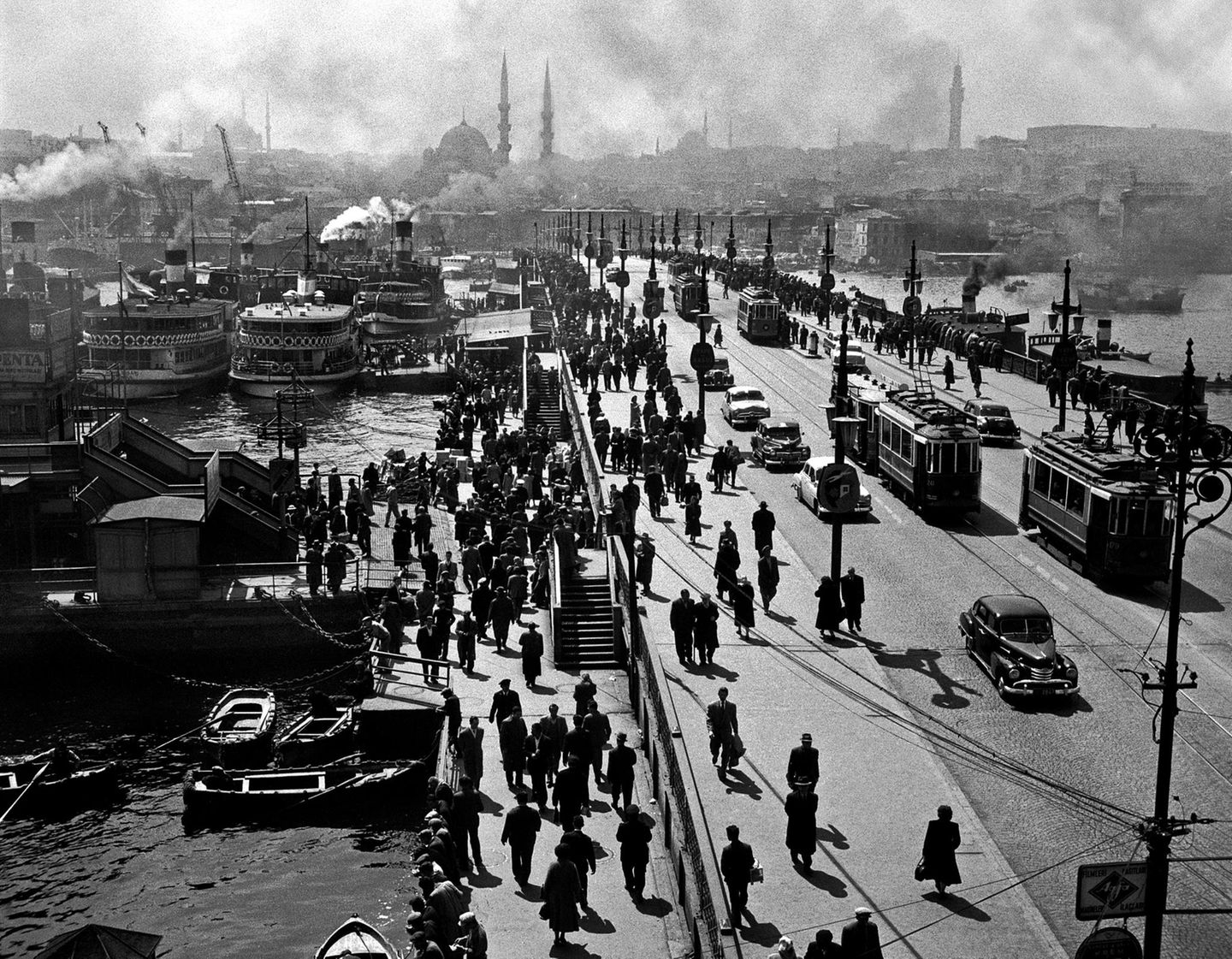 Geschäftig geht es zu auf und neben der Galatabrücke am Mittag eines Tages im Jahr 1954. Das Bauwerk verbindet Nord- und Südufer des Goldenen Horns, eines vom Bosporus abgehenden Meeresarms, der rund sieben Kilometer in den europäischen Teil Istanbuls hineinragt. Istanbul ist seit jeher geprägt von der einzigartigen Lage am Wasser. Der Bosporus, der den europäischen Kontinent vom asiatischen trennt, sowie seine Seitenarme sind wie Lebensadern für die Stadt. So lässt der Warenverkehr zur See den Ort über die Jahrhunderte zur wohlhabenden Metropole heranwachsen.