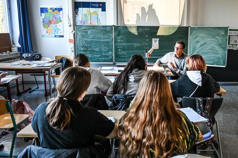 Ein Lehrer mit Schülern in einem Klassenraum