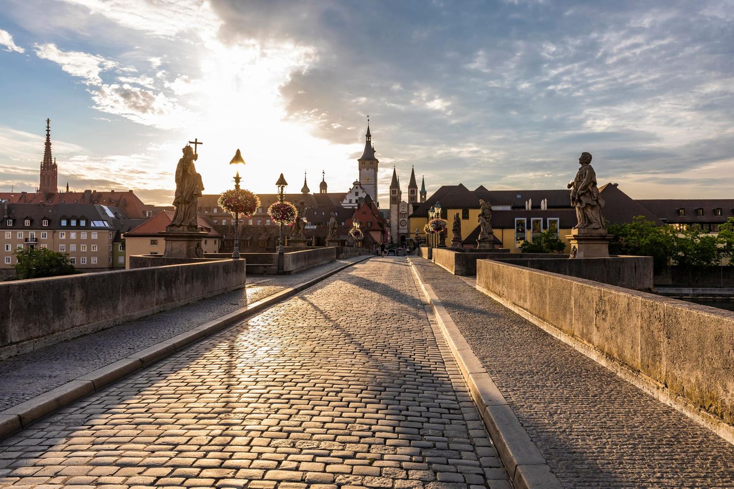 Germany, Bavaria, Wurzburg, Empty Alte Mainbrucke bridge at cloudy sunset