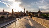 Germany, Bavaria, Wurzburg, Empty Alte Mainbrucke bridge at cloudy sunset