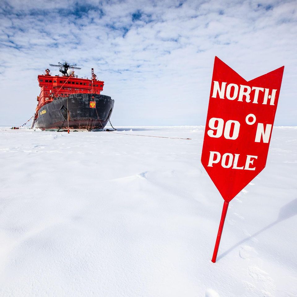 Ein Eisbrecher und Schild am geographischen Nordpol