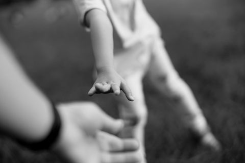 Kind streckt Hand nach Mann aus