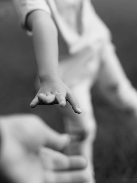 Kind streckt Hand nach Mann aus