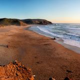 Praia do Amado an der Atlantikküste an der Algarve, Portugal bei Abendlicht kurz vor Sonnenuntergang. Sunset at Praia do Amado in the Costa Vicentina natural park at the Atlantic Ocean at the Algarve, Portugal.