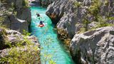 Kayakkers on the emerald Soca near Bovec in Slovenia. This green colored river, originating in the Triglav mountains, is famous for all kinds of white water activities.