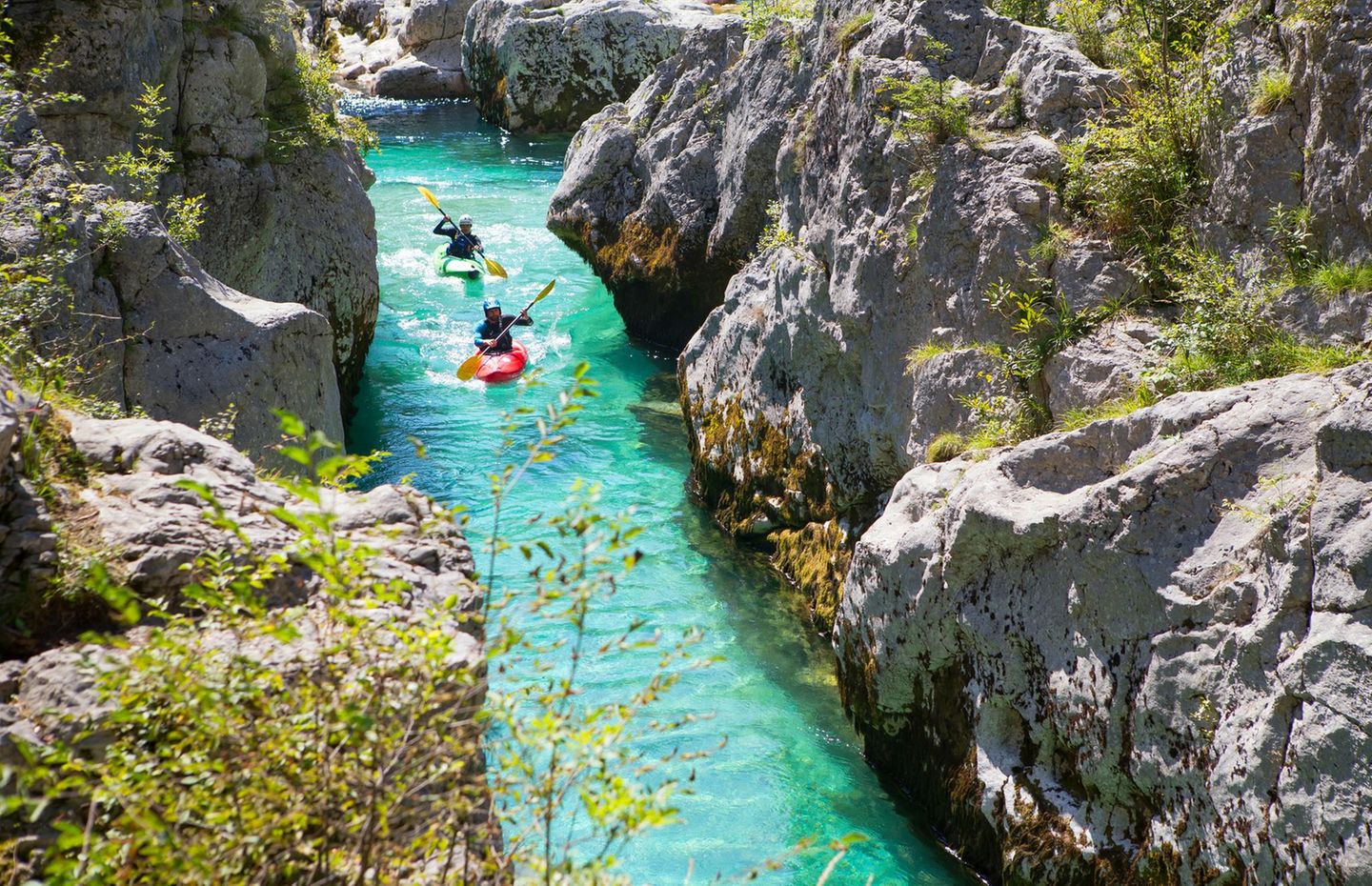 Kayakkers on the emerald Soca near Bovec in Slovenia. This green colored river, originating in the Triglav mountains, is famous for all kinds of white water activities.