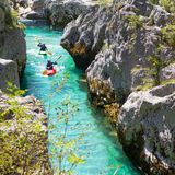 Kayakkers on the emerald Soca near Bovec in Slovenia. This green colored river, originating in the Triglav mountains, is famous for all kinds of white water activities.