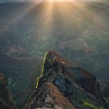 Ein Mann steht vor dem Waimea Canyon bei Sonnenaufgang, Kauai, Hawaii, Amerika, USA