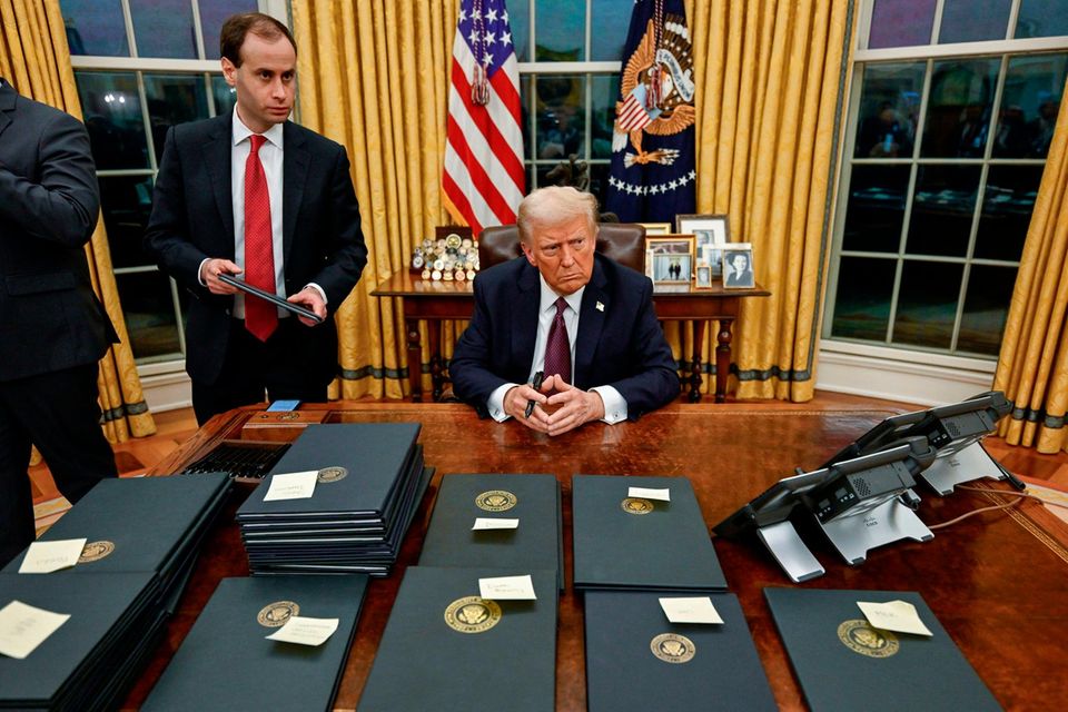Donald Trump im Oval Office vor ihm signierte "executive orders"