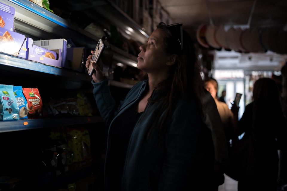 Mit Handylicht suchten Menschen in Geschäften nach Lebensmitteln. Bezahlen konnten sie allein bar – digitale Transfers waren während des Backouts nicht möglich  1.4993