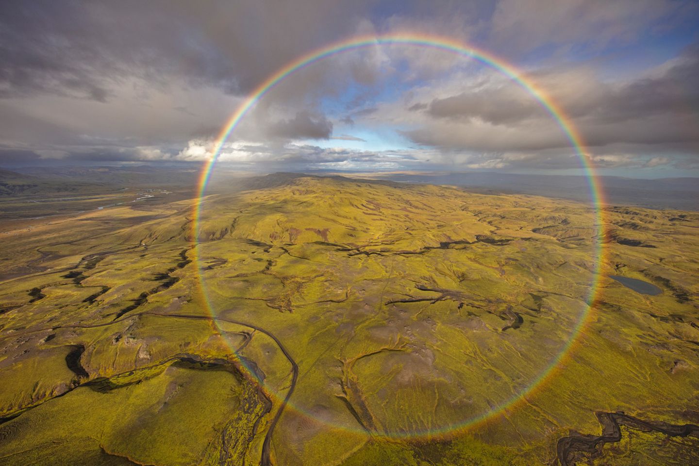 Magisches Portal über Island? In 300 Meter Höhe gelang es Peter Schwager, ein besonderes Naturschauspiel festzuhalten: Aus einem Hubschrauber ohne Türen heraus knipste er den runden Regenbogen über den Weiten der isländischen Natur. 