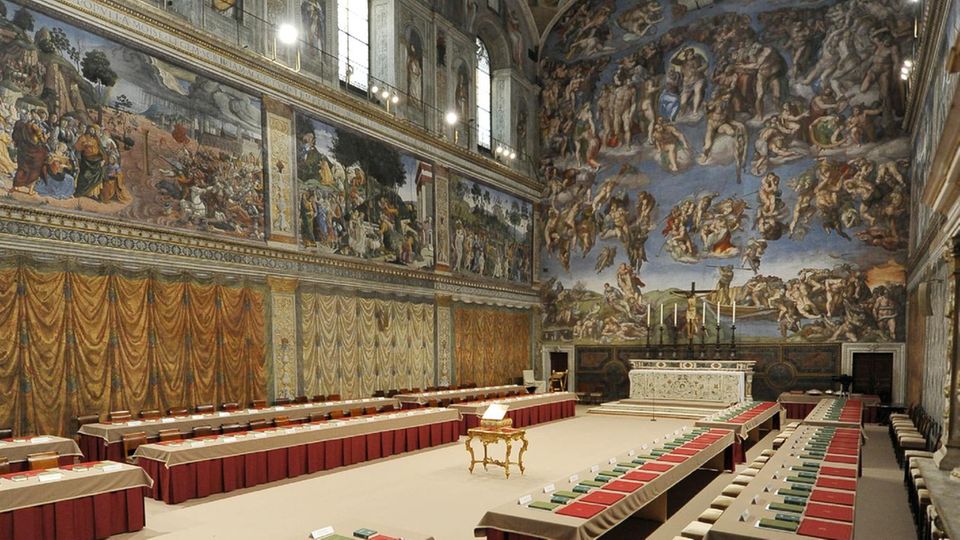 Die Sixtinische Kapelle ist vorbereitet für die Wahl, hier 2013. An jeder Seite stehen zwei Reihen aus Tischen auf einem eigens ausgelegten Untergrund, um den kostbaren Kapellenboden zu schützen. Auf den Tischen die Namenskarten für die Kardinäle