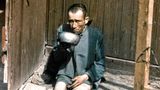 Ein befreiter KZ- Insasse in Buchenwald sitzt erschöpft am Boden