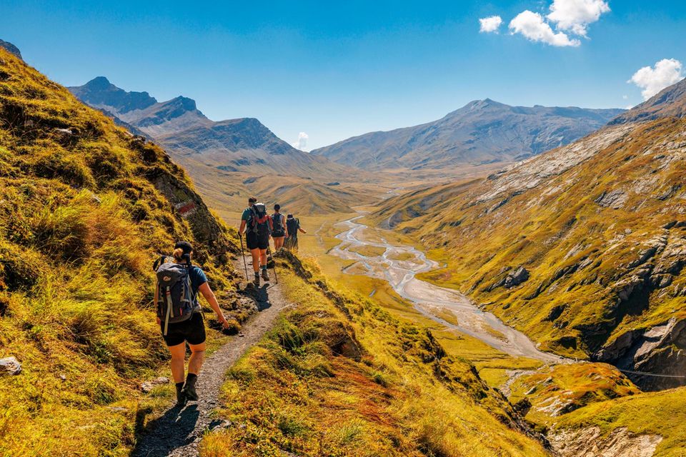 Der Rein da Sumvitg, ein Zufluss des Rheins, windet sich tief unterhalb der Wandernden in Schleifen durch das Tal