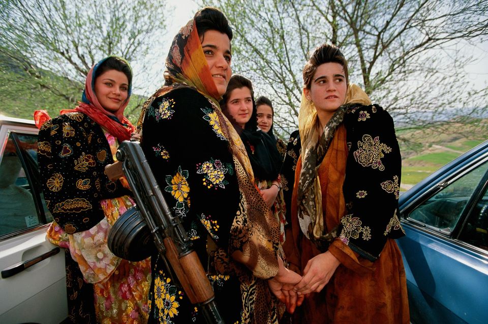 Junge, bewaffnete Kurdinnen in traditioneller Kleidung besuchen eine Hochzeit 1.5004