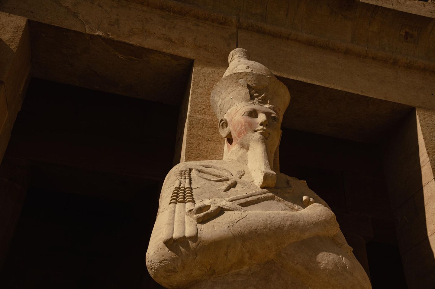 Zerschlagen und vergraben Altägyptische Statue der Hatschepsut als Osiris mit gekreuzten Armen, Götterbart und Krone von schräg unten