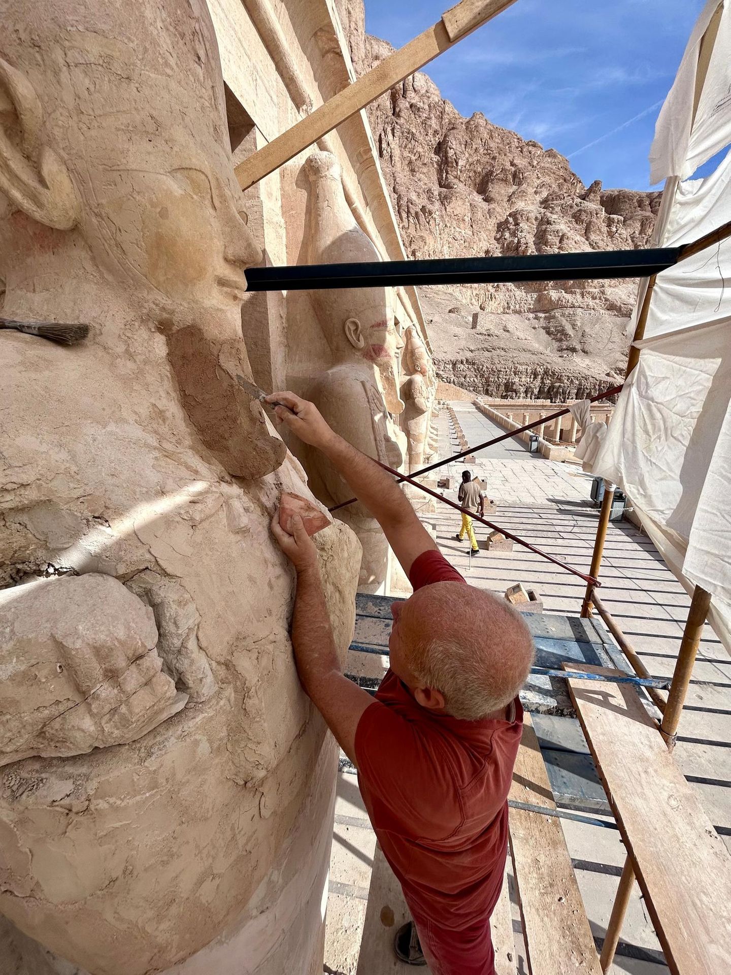 Beim Barte der Pharaonin Ein Bildhauer auf einem Baugerüst ergänzt den Bart einer Osirisstatue der Hatschepsut
