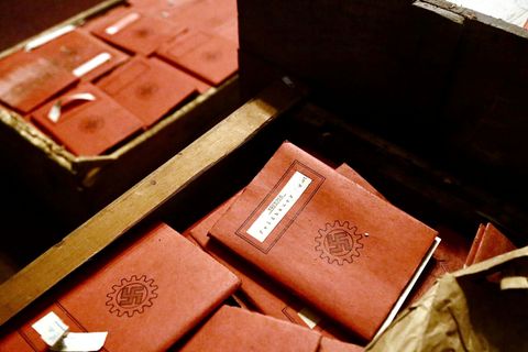Kisten gefüllt mit braunen Notizbüchern mit Hakenkreuz-Emblem